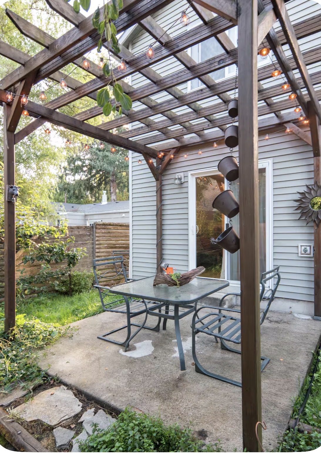 Backyard pergola with string lights and patio seating